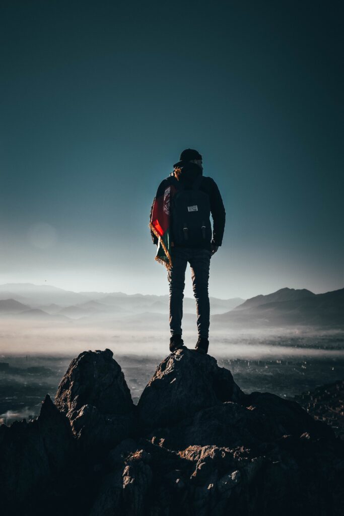 Bilden visar en person på backpacking med en vandringsryggsäck på ryggen. Att packa rätt liggunderlag, sovsäck och gaskök till backpacking är viktigt för en trivsam vandring.