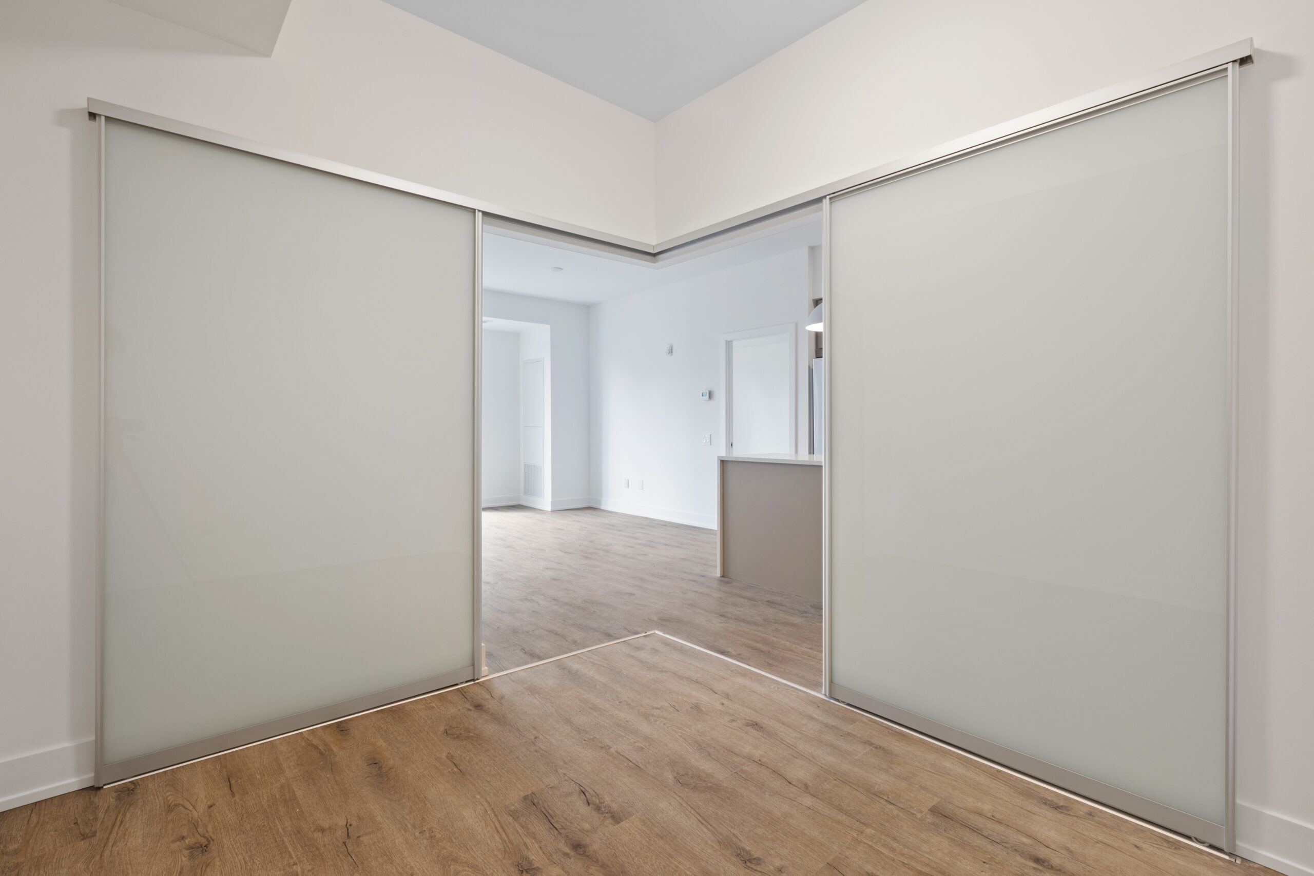 Bilden visar: En stilfull skjutdörr vägg som skiljer mellan vardagsrummet och arbetsrummet i en öppen planlösning.